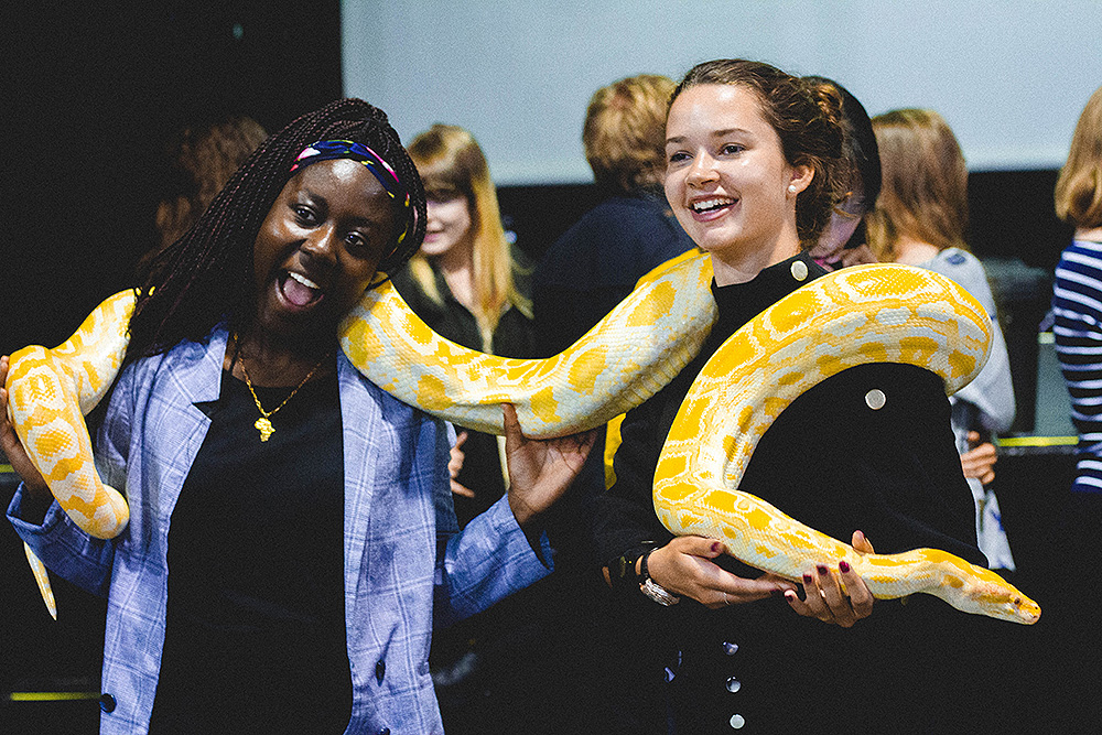 Students holding a snake