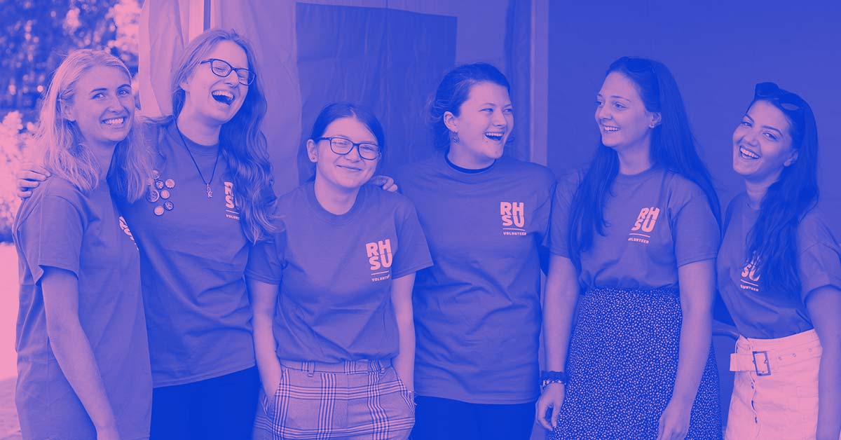 A group of student volunteers wearing RHSU t-shirts and smiling