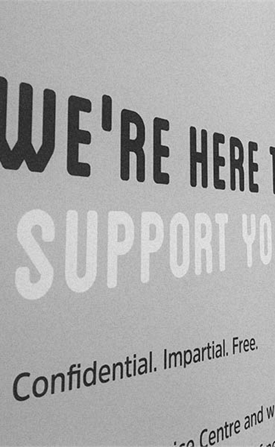 A sign outside the Advice Centre reading 'We're here to support you'