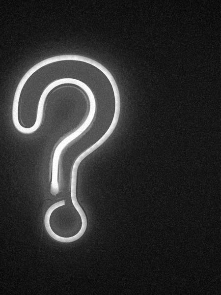 A neon question mark sign on a wall