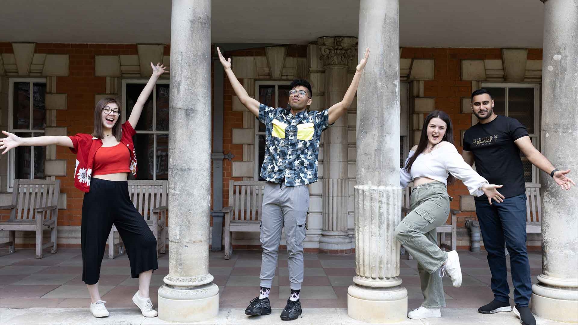 RHSU's 2022-23 Officers throwing their arms in the air by the columns in Founder's Quads