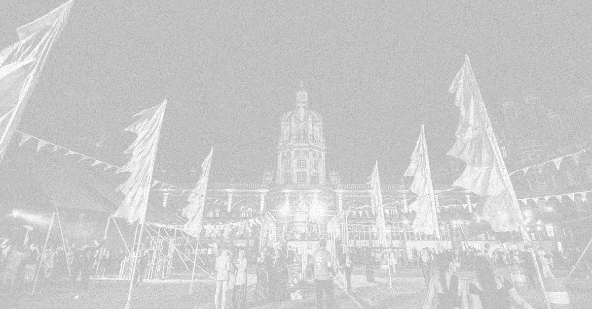 A photograph of Founder's Quad, with huge flags lining the footpath