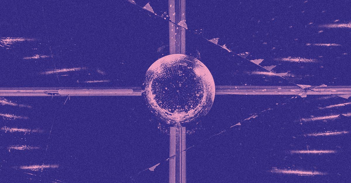 A glitter ball hanging from the ceiling of the marquee, with lines of flag bunting zig zagging across around it