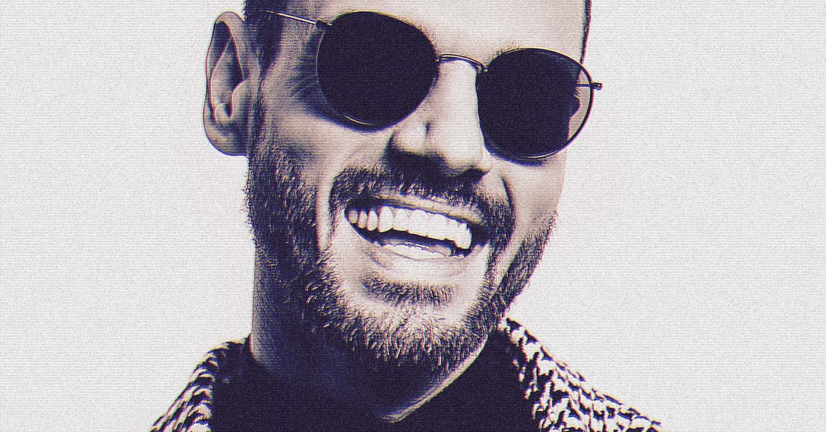 Tony Perry pure cheesing, wearing a blazer and sunglasses