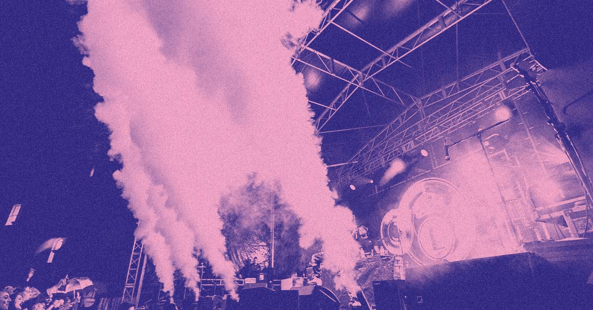 A photograph of four CO2 cannons firing in front of the main stage