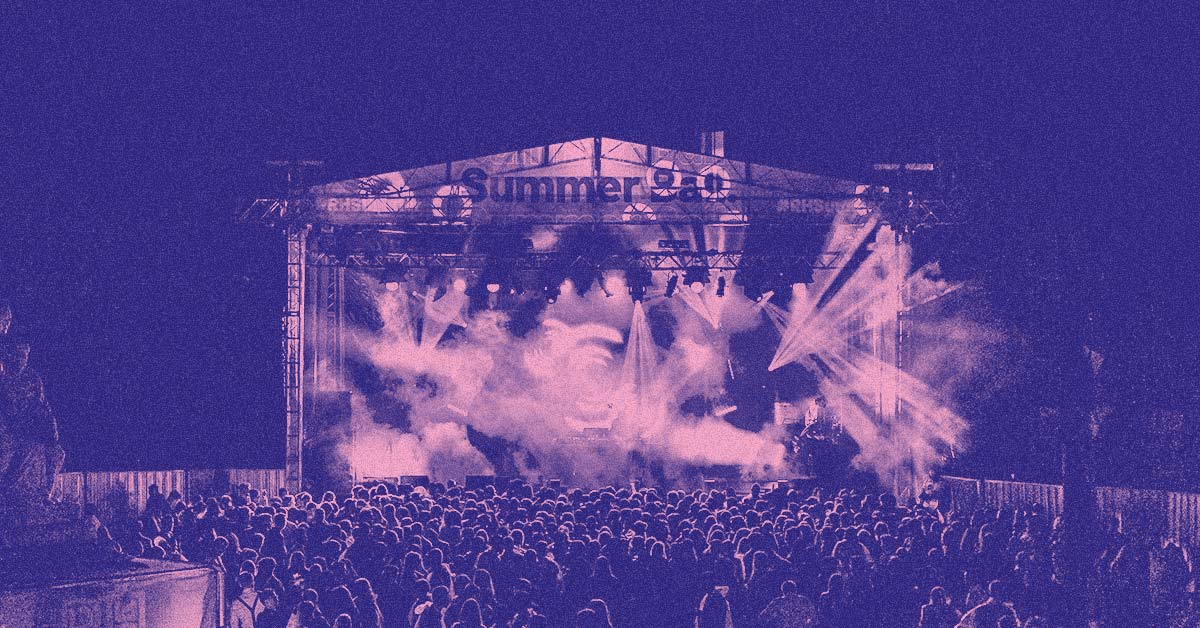 The Festival Stage lit up with incredible productions lights, with a huge crowd silhouetted in front